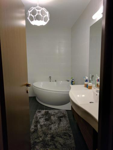 a bathroom with a tub and a sink and a mirror at Juniper Apartment in Braşov