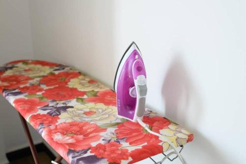 a iron sitting on top of a table with flowers at Amaze Residence luxury 2bedroom apartment 2 in Boralesgamuwa