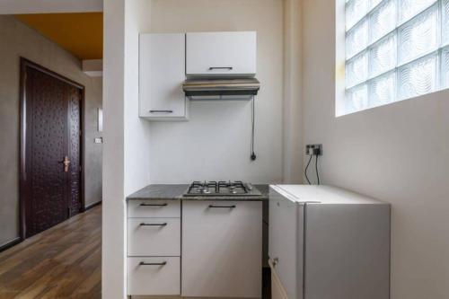 a white kitchen with a stove and a refrigerator at Amaze Residence luxury 2bedroom apartment 2 in Boralesgamuwa