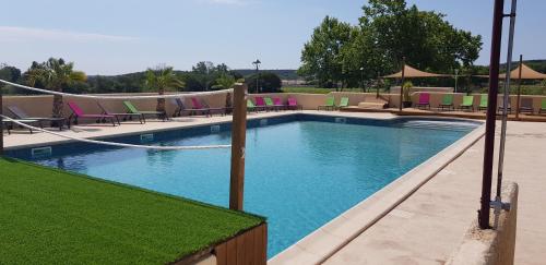 a large swimming pool with chairs at Camping L'Evasion in Fontès