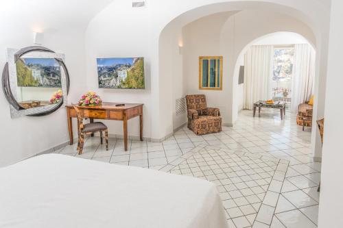 a bedroom with a bed and a desk with a mirror at Hotel Marina Riviera in Amalfi