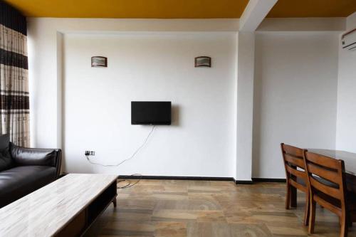 a living room with a couch and a tv on a wall at Amaze Residence luxury 2 bedroom apartment 3 in Boralesgamuwa