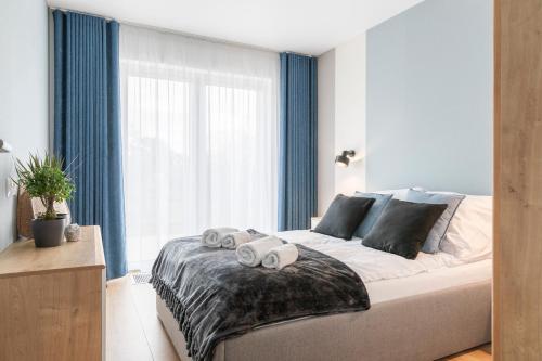 a bedroom with a large bed with towels on it at Kamienica Parkowa in Dąbki