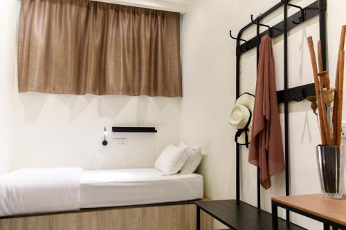 a bedroom with a bed and a window and a table at Kuree Hut in Semporna
