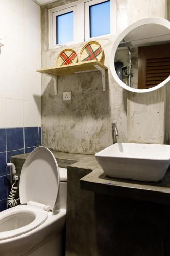 a bathroom with a toilet and a sink and a mirror at Kuree Hut in Semporna