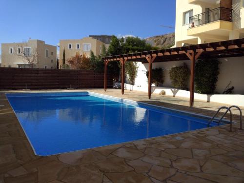 una piscina con pergolato accanto a un edificio di Panoramic Eden a Paphos