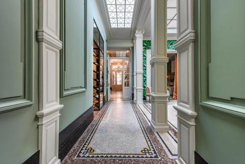 a corridor of a building with columns and a ceiling at Cabosse, Suites & Spa in Antwerp