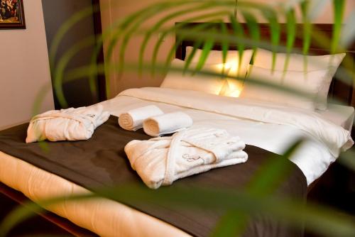 a bed with towels and pillows on it at Bahus Inn in Belgrade