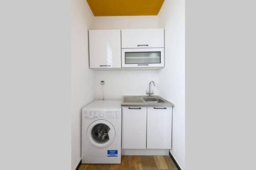 a kitchen with a washing machine and a microwave at Amaze Residence luxury 2 bedroom apartment 5 in Boralesgamuwa