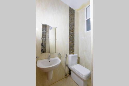 a white bathroom with a sink and a toilet at Amaze Residence luxury 2 bedroom apartment 6 in Boralesgamuwa