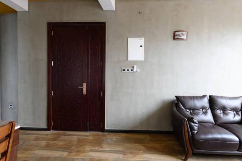a living room with a leather couch and a door at Amaze Residence luxury 2 bedroom apartment 6 in Boralesgamuwa