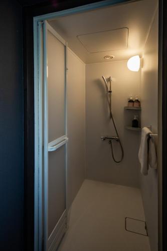 a bathroom with a shower and a shower head at UNKNOWN KYOTO in Kyoto