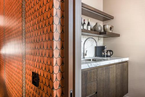 a kitchen with a sink and a counter with a wall at Cabosse, Boutique Palace & Spa in Antwerp