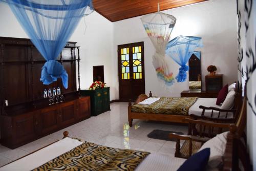 Un dormitorio con dos camas y una mesa y sillas. en Antique Tourists Lodge, en Kandy