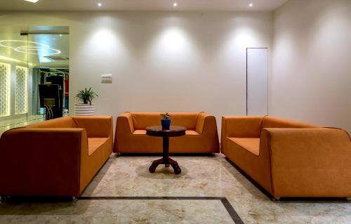 a waiting room with two orange chairs and a table at The Fern Residency Vijayapura in Bijāpur