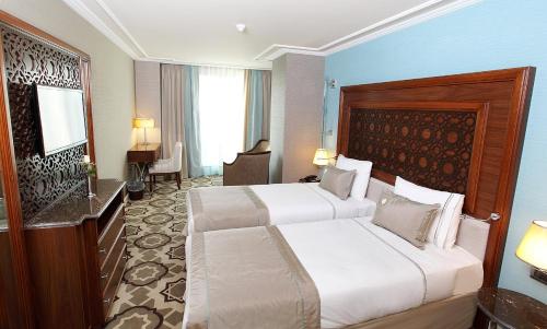 Habitación de hotel con 2 camas y escritorio en Grand Durmaz Hotel, en Estambul