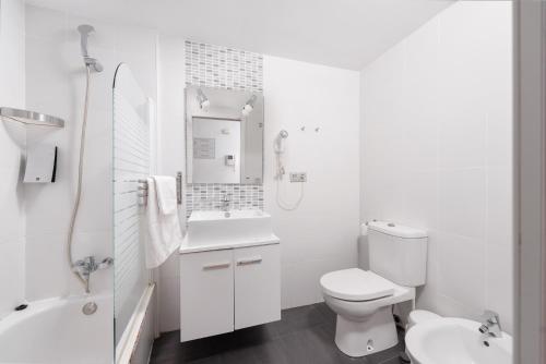a white bathroom with a toilet and a sink at Apartamentos Globus by Be Alicante in Alicante