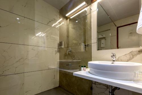 a bathroom with a sink and a mirror at The Fern Residency Vijayapura in Bijāpur