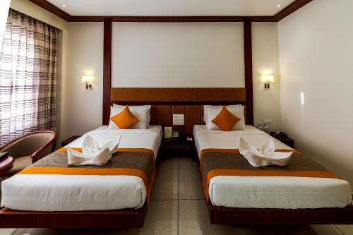 a hotel room with two beds and a window at The Fern Residency Vijayapura in Bijāpur