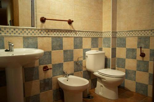 a bathroom with a toilet and a sink at EL MESÓN DE GREDOS in Navarredonda de Gredos