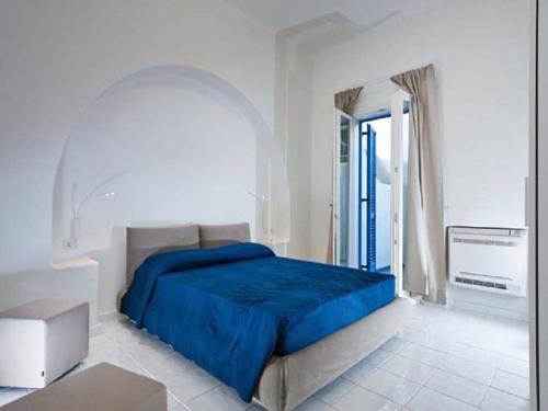 a bedroom with a blue bed and a window at NerOssidiana in Acquacalda