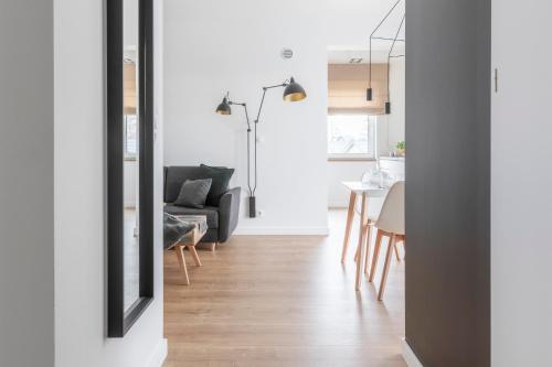a living room with a black couch and a table at Kamienica Parkowa in Dąbki