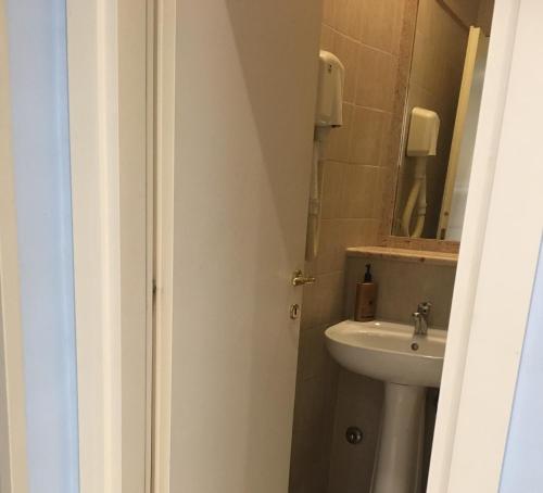 ein weißes Badezimmer mit einem Waschbecken und einem Spiegel in der Unterkunft Residence Lodi in Rom