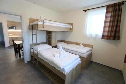 a room with two bunk beds and a table at Apartmány AURA in Boží Dar