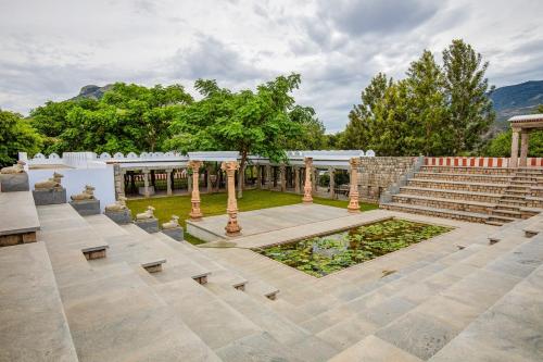 an outdoor amphitheater with stairs and a pond at My Village - Eco Rural Resort in Coimbatore