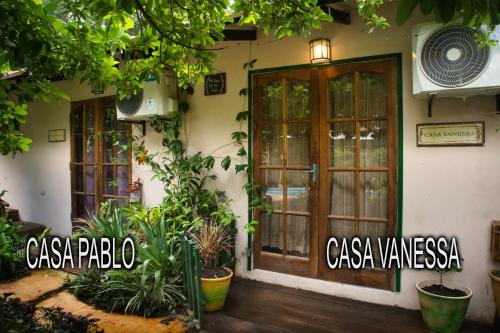 a building with doors and plants in front of it at Vacaciones Aregua CASA VANESSA in Areguá