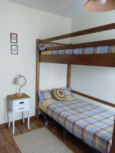 a bedroom with two bunk beds and a night stand at La Majada de Alameda in Alameda del Valle