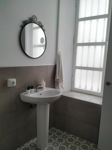 a bathroom with a sink and a mirror and a window at SALOTUR Tomas de Ibarra in Seville