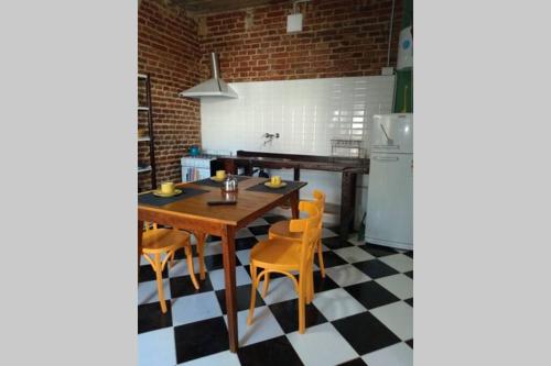 cocina con mesa, sillas y nevera en Departamento Amoblado con Cochera en Villa María