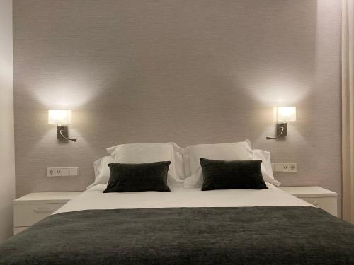a bedroom with a large bed with two pillows at HNN GRANADA in Granada