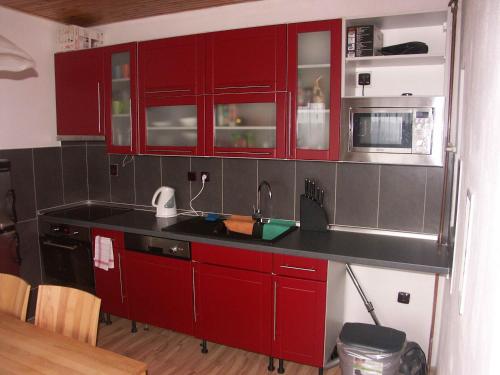 a kitchen with red cabinets and a sink at Chata OSTRUZINA 10+2 in Lipno nad Vltavou