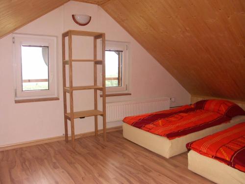a attic room with two beds and a book shelf at Chata OSTRUZINA 10+2 in Lipno nad Vltavou