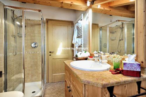 a bathroom with a sink and a shower at Luxury Exclusive Attic in Pinzolo