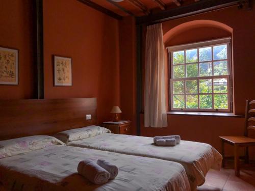 Casa Yanes Casas Rurales في Breña Alta: غرفة نوم بسريرين ونافذة