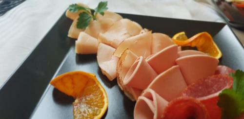 a plate of food with meat and orange slices at Hotel Altberesinchen in Frankfurt/Oder