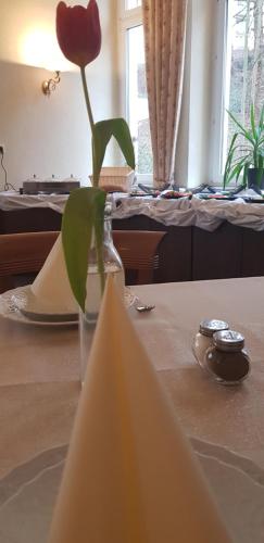 a vase with a flower in it on a table at Hotel Altberesinchen in Frankfurt/Oder