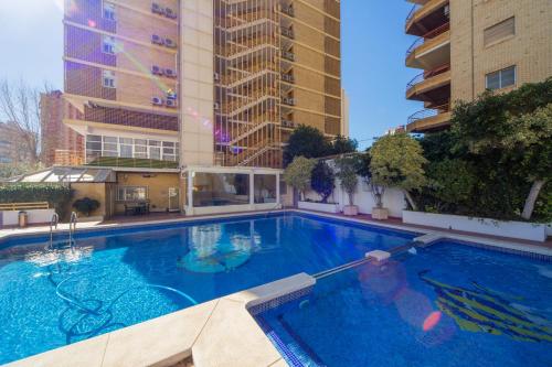 a pool with a pool table and chairs in it at Apartamentos Viña del Mar in Benidorm
