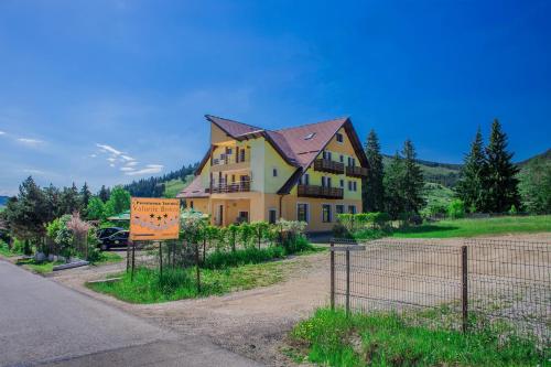 a house on the side of a road with a fence at Pensiunea Valurile Bistritei in Vatra Dornei