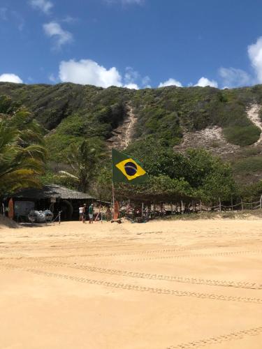 un drapeau jaune et vert sur une plage de sable dans l'établissement Blue House, à Baía Formosa