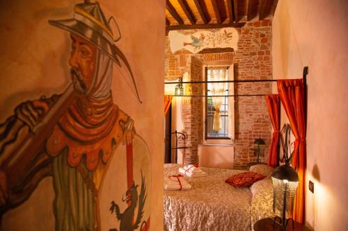 Habitación con cama y pintura en la pared en Antica Corte dei Principi charming rooms, en Lucca