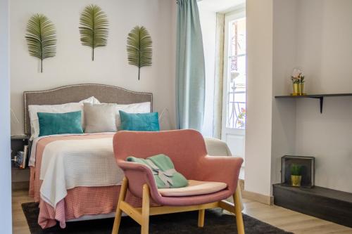 1 dormitorio con 1 cama y 1 silla rosa en BF Suites & Apartments, en Oporto