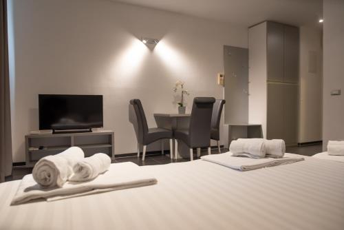 a hotel room with two beds and a table with a television at Whitehouse Apartments in Makarska