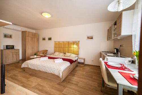 a bedroom with a bed and a table and a kitchen at Penzion Kateřina in Mikulčice