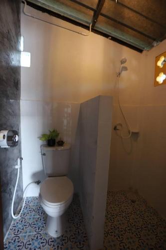 a bathroom with a toilet and a shower at Thipwararom homestay in Takua Pa