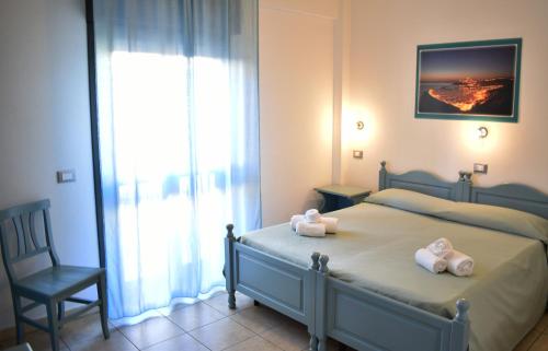 una camera da letto con un letto e due asciugamani di Hotel Residence Ampurias a Castelsardo