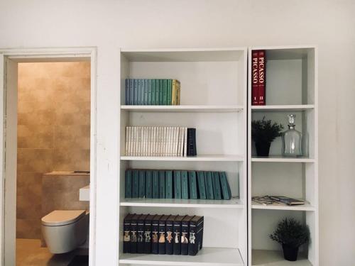 a white book shelf with books on it at Schöne Villa in Nianing, Mbour, Senegal in Nianing